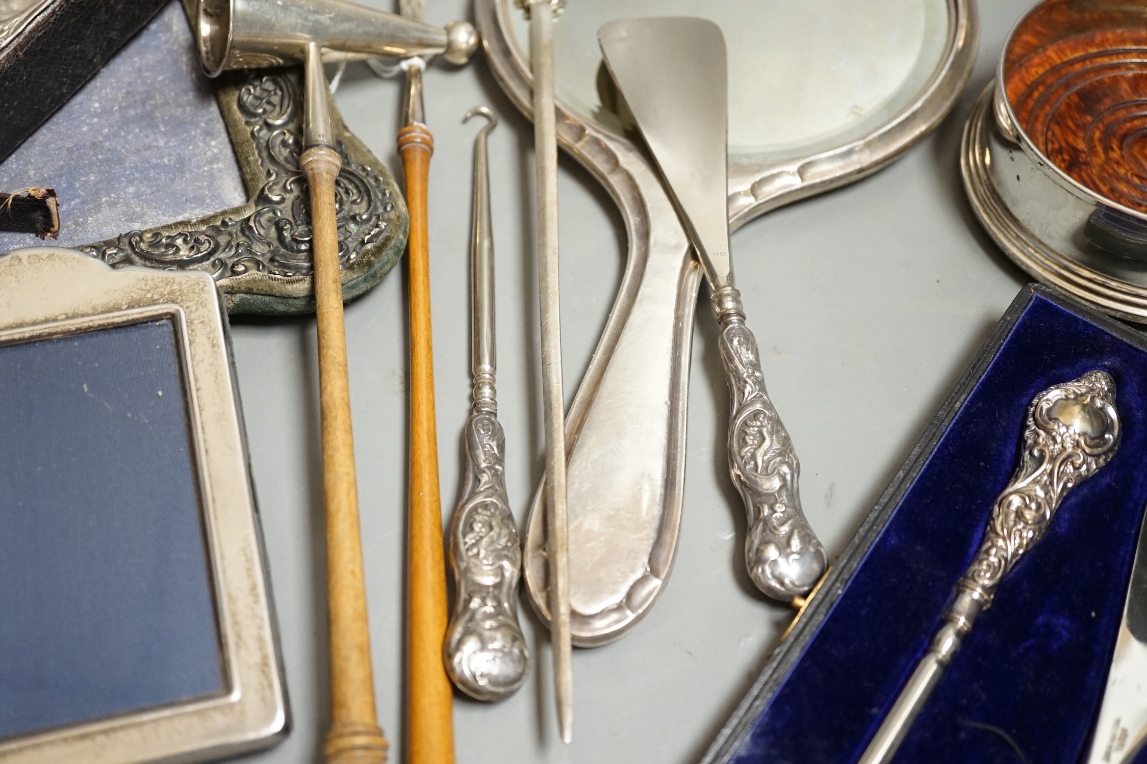 A group of small silver including two mounted photograph frames, one Birmingham, 1901, a mounted bible case, candlestick snuffer, coaster, etc.